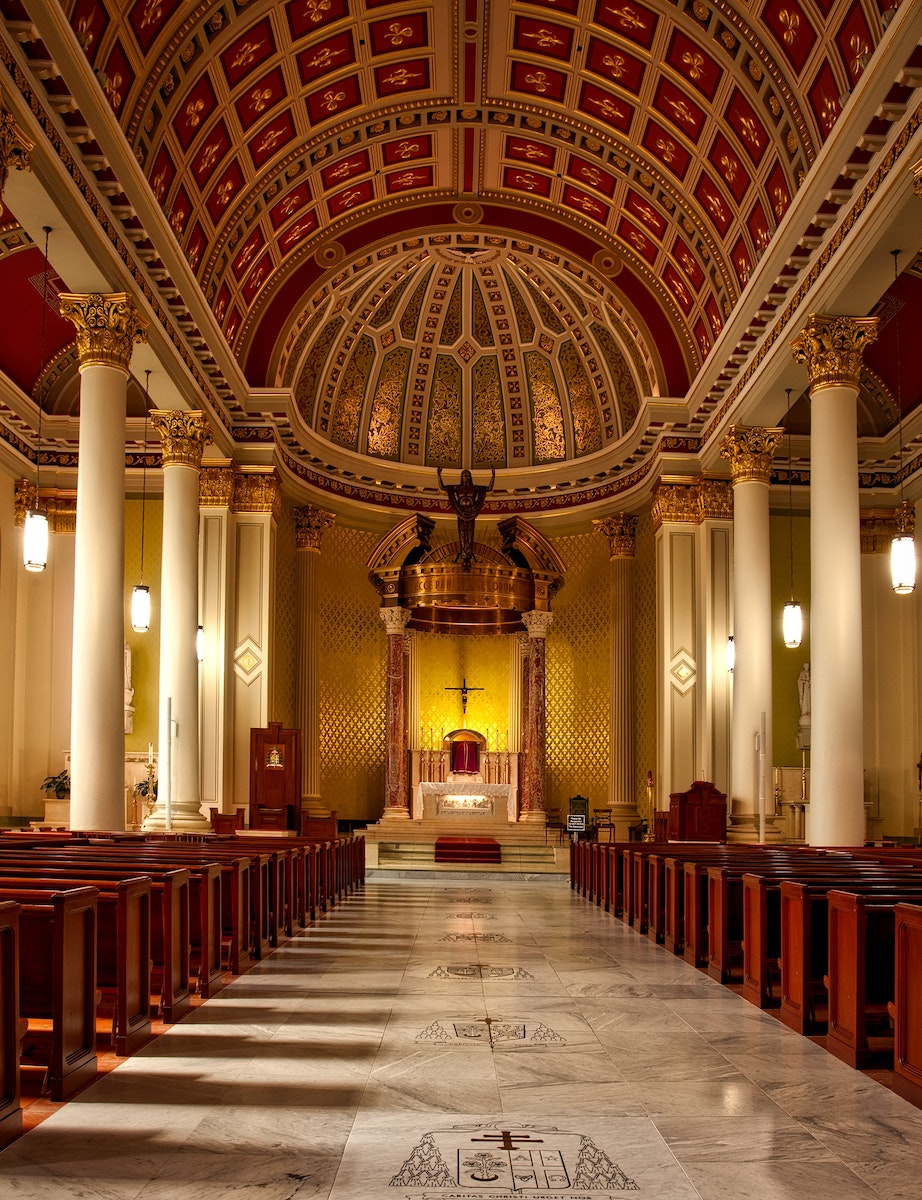 Empty Cathedral Seats and Hallway With Lights Turned on